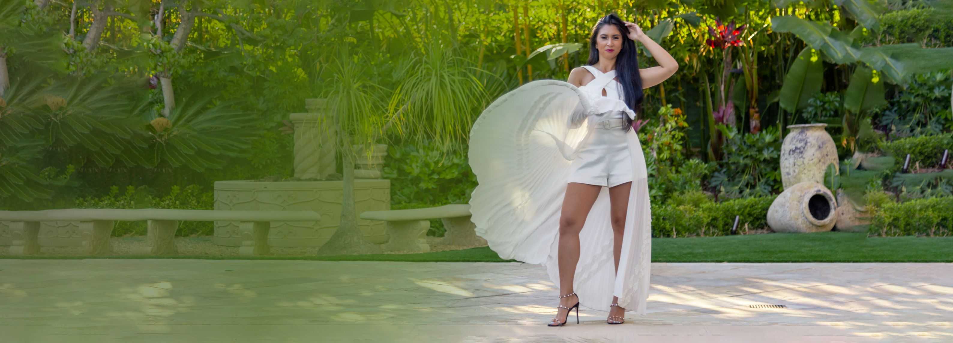 Nicole with a bride dress on heels twirling her gown on a greenish background.